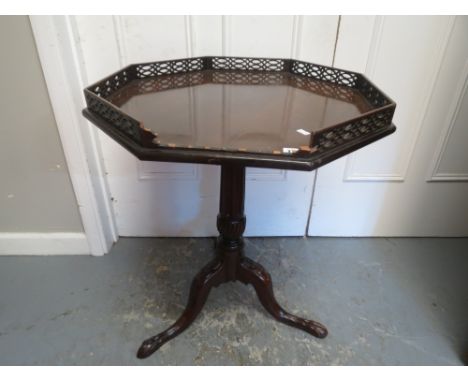 A 19th century mahogany carved octagonal topped tilt top tripod table with a galleried top, standing on ball and claw feet A/