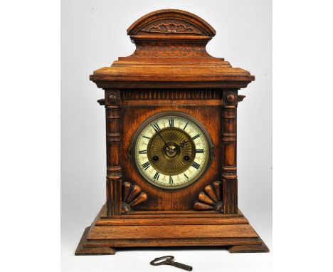 An Oak cased mantle clock with Roman numerals to chapter ring.