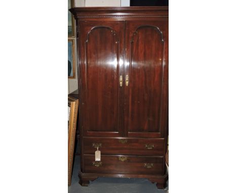 A reproduction American style mahogany wardrobe with two arched paneleed doors over two drawers on bracket feet, W. 110cm