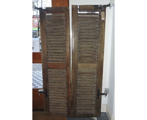 A pair of vintage French hardwood window shutters with cast metal brackets, each 186 x 50 cms