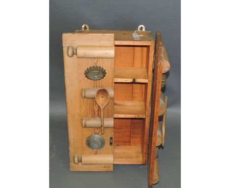 A rustic design pine kitchen wall cabinet, designed by Steve Handley, the doors applied with vintage rolling pins, spoons and