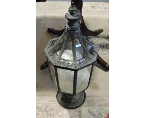 A verdigris metal glazed octagonal tulip form lantern with tea light interior. H. 70cm.