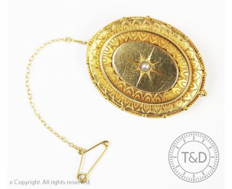 A Victorian seed pearl set mourning brooch, set with a central seed pearl, in a etruscan decorated surround, all in yellow me