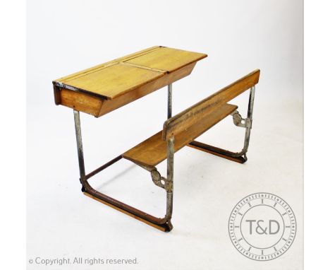 A pair of vintage school desks, the twin combined  beech wood desks and benches mounted upon tubular metal bracket supports, 