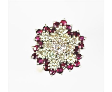 A diamond and untested ruby cluster ring, the central diamond within a surround of six diamonds and a further surround of six