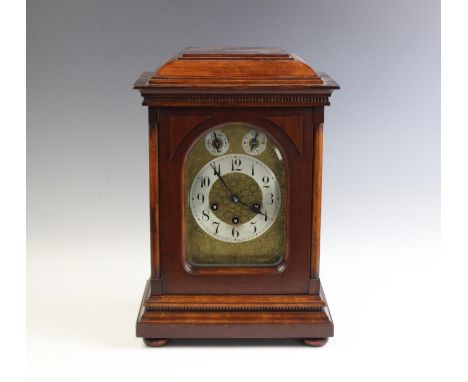 An early 20th century German bracket clock by Junghans, the walnut and beech case housing the 14cm brass and silvered dial wi