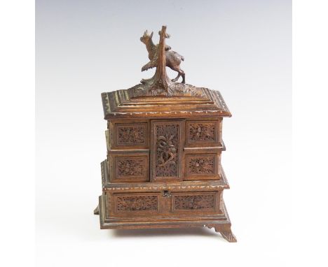 An early 20th century Black forest folding jewellery box, surmounted with a carved deer by a tree stump, above an arrangement