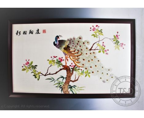 A Chinese silk embroidery depicting a peacock perched in a tree, 62cm x 106.5cm, framed and glazed, with an Indian embroidere