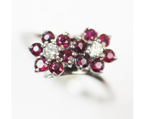 A ruby and white sapphire floral cluster ring, comprising two brilliant cut white sapphires, each claw set to a cluster surro