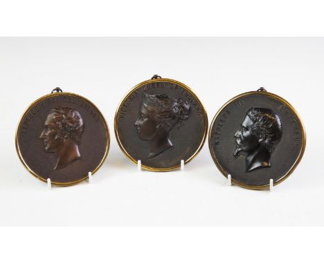 A group of three 19th century circular Bois Durci plaques, comprising: a relief decorated with a portrait of Queen Victoria I