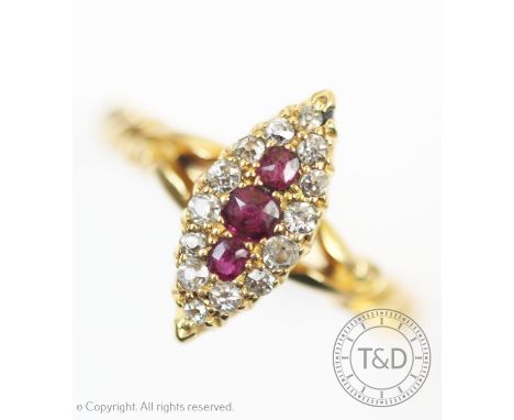 An Edwardian ruby and diamond ring, the marquise shaped ring set with three central graduated rubies within a diamond set sur