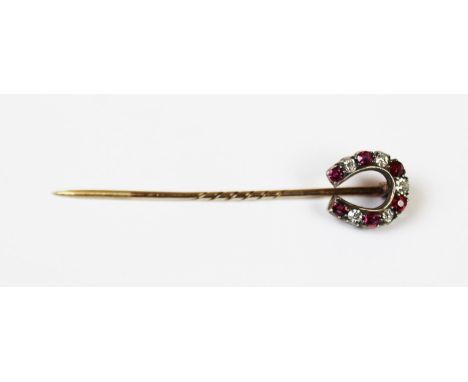 An early 20th century diamond and ruby set horse shoe stick pin, claw set with alternating old cut diamonds and rubies, all i