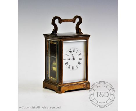 An early 20th century brass cased carriage clock, having a 7cm white enamel dial and black Roman numerals enclosing the two t