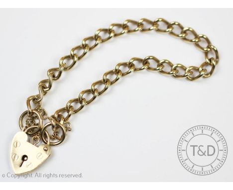 A 9ct gold curb link bracelet, with attached heart shaped padlock clasp and safety chain, gross weight 15.6gms For condition 