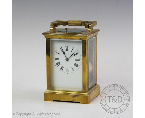 An early 20th century French brass cased repeating carriage clock, with an angular swing handle above the 6cm white enamel di