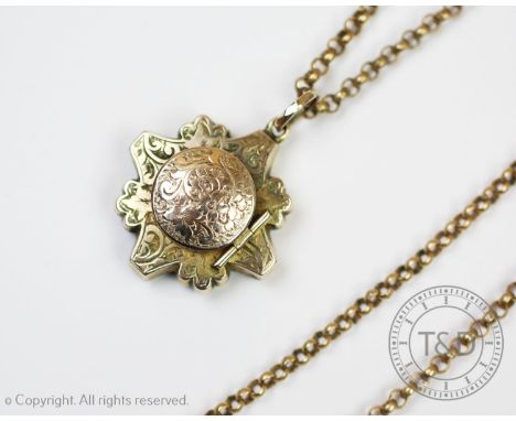 An Edwardian mourning pendant, of cross form with curling tendril detail throughout, surmounted by a circular hinged cover, e