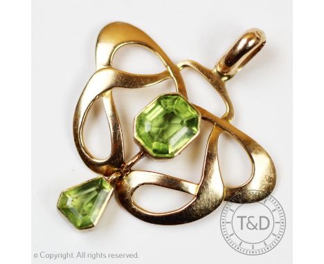 An early 20th century Art Nouveau pendant, set with two step cut peridots, bezel set to the yellow metal openwork pendant and