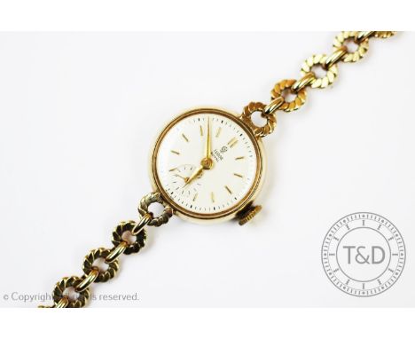 A 9ct gold lady's Tudor wristwatch, Chester 1955, the case enclosing a white enamel dial with gold batons and subsidiary seco