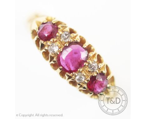 A seven stone ruby and diamond 18ct gold ring, the three graduated rubies interspersed with four small diamonds, all set in 1