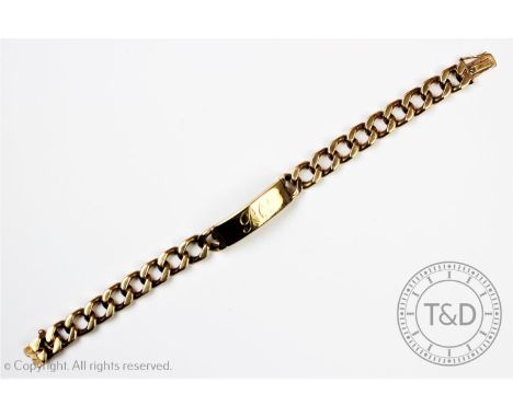 A gentleman's 9ct gold bracelet, cable link chain with engraved panel, hallmarks to reverse for Birmingham 1973, tongue and b