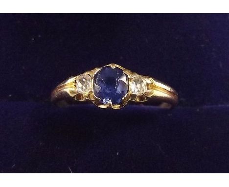 An 18 carat gold ring set sapphire flanked by two diamonds, size K