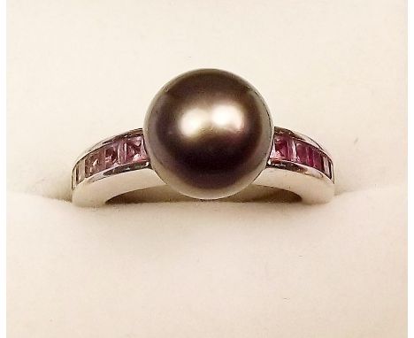 An 18 carat white gold ring set black pearl on pink sapphire set shoulders - 7.5g, size J and a half