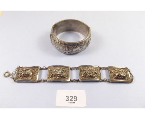 An Indian white metal hinged bangle and a similar bracelet, both with elaborate decoration