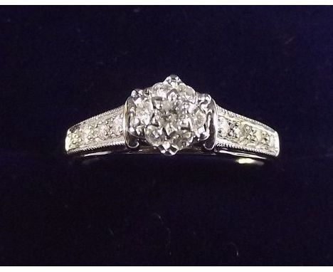 A 9 carat white gold diamond ring on diamond set shoulders, size L