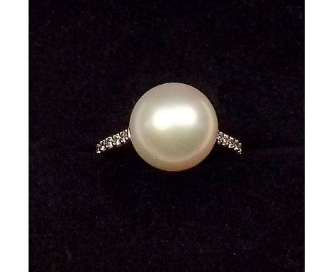 A fine 18 carat white gold ring set large white pearl on diamond shoulders, size L