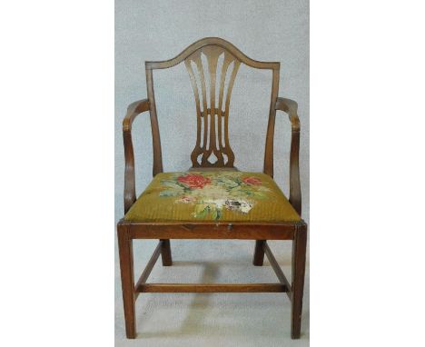 A Georgian mahogany framed armchair with pierced shaped splat above tapestry upholstered drop in seat on square tapering stre