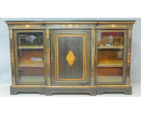 A late Victorian ebonised and satinwood inlaid credenza with ormolu mounts and central panel door flanked by bookcase section