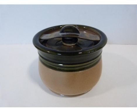 A green glazed stoneware ceramic tobacco jar by Royal Doulton with metal swivel patented mechanism to lid. Makers stamp to th