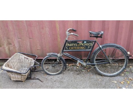 A vintage Butcher's bicycle, black painted frame, with advertising sign for Hocket and Pocket High St Cookham, with Partys an