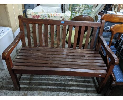 A stained wooden slatted two-seater garden bench 89cm x 121cm x 60cm Location:If there is no condition report shown, please r