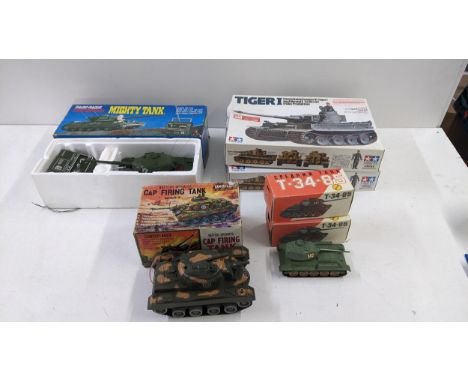 Boxed model tanks to include two tamiya Tiger 1 tanks both incomplete, two Russian T-34-85's a Marx battery operated, cap fir