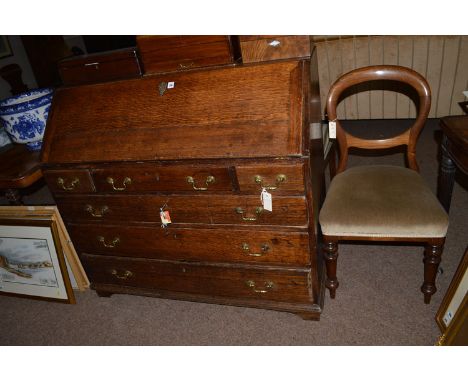 A Georgian oak bureau, the fall-flap enclosing a plain interior, fitted three short and three long graduating drawers with br