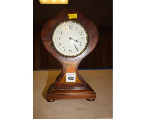An Edwardian inlaid mahogany balloon-shaped mantel clock with enamel dial, raised on square base.