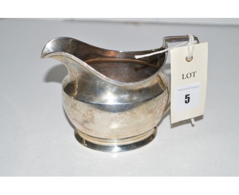 A Georgian silver helmet form cream jug, by Alexander Field, London 1802, with reeded rim.