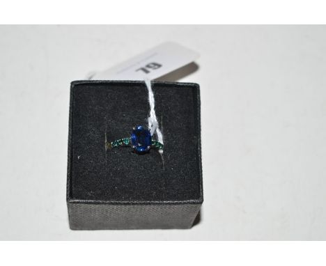 A kyanite and garnet ring, the oval kyanite flanked by green garnet shoulders, on 9ct. white gold shank, ring size R.