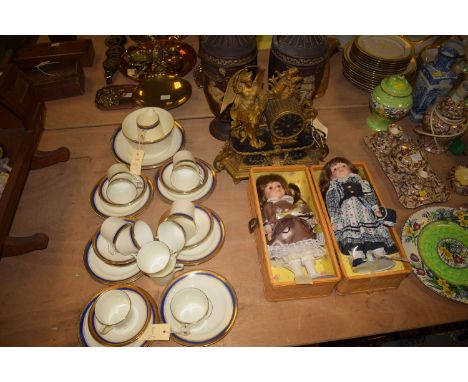 A tea set; two dolls; a French style clock; and a pair of vases.