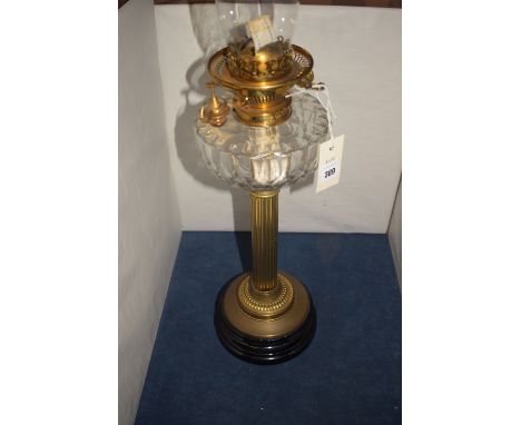 A 19th Century table oil lamp by Hinks & Sons, with glass chimney and glass reservoir, raised on a reeded brass column on cir