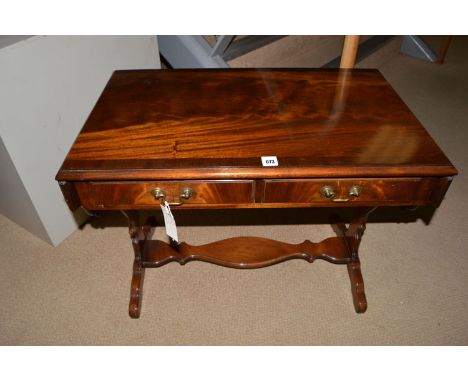 A reproduction mahogany miniature sofa style occasional table, fitted two shallow drawers in one side frieze, with two shaped