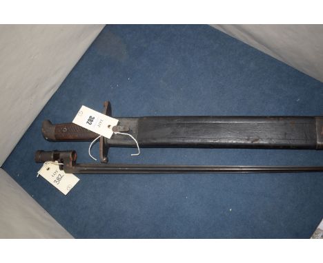 An early 20th Century metal machete with metal and leather scabbard; and a tapering four-sided early 20th Century bayonet, No