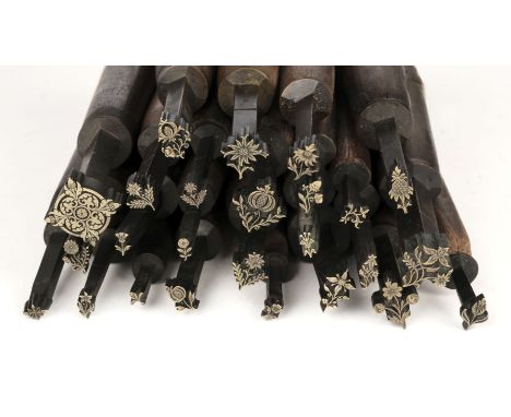 * Decorative finishing tools. 25 brass decorative finishing tools, comprising mostly centre tools, many with floral motifs et