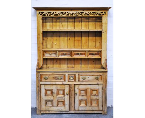 Pine dresser, fretted scrolled frieze, with a two-shelf Delft rack, incorporating four drawers, the base with three frieze dr
