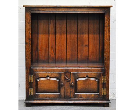 Reproduction oak open bookcase by Titchmarsh & Goodwin, with single shelf, two panelled doors under, width 83cms.