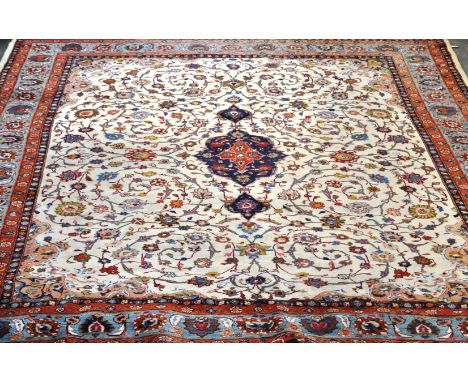 Tabriz pattern carpet, floral decoration on a blue ground, the border within guards, 393 x 297cms.