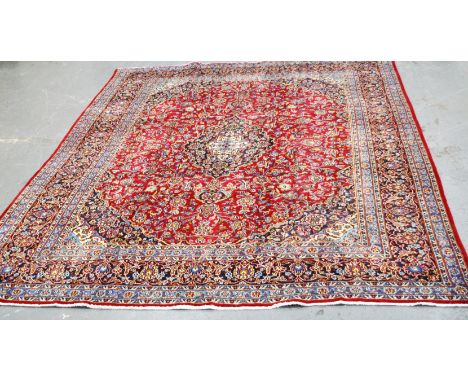 Tabriz pattern carpet, central medallion on a patterned floral red field, the border within guards, 290 x 390cms.