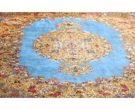 Persian carpet, on a blue field, central medallion, with a multi floral boarder, circa 1960. 330 x 244cms.