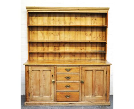 Pine kitchen dresser, matched three shelf Delft rack, the base with a bank of four drawers, flanked by panelled doors, plinth